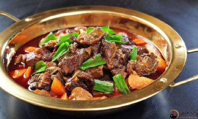 我梦见在一个拥挤的场景中,许多人围坐在一起大快朵颐,享用着美味的羊肉料理